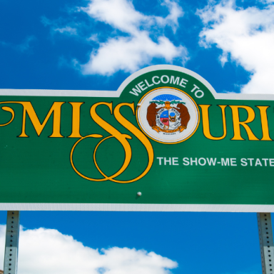 Welcome sign for Missouri, featuring "The Show-Me State" against a blue sky.